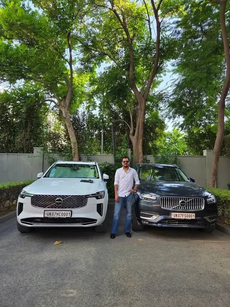 Tushar Kumar standing between two cars
